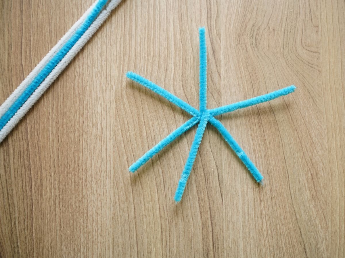 blue pipe cleaner cut and twisted into snowflake shape