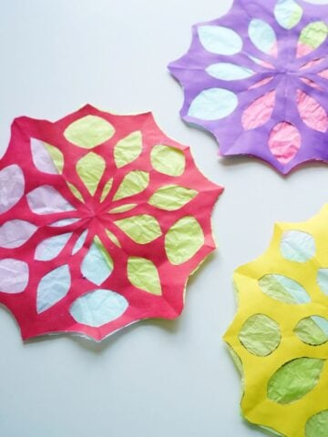 close up of 3 paper snowflake sun catchers