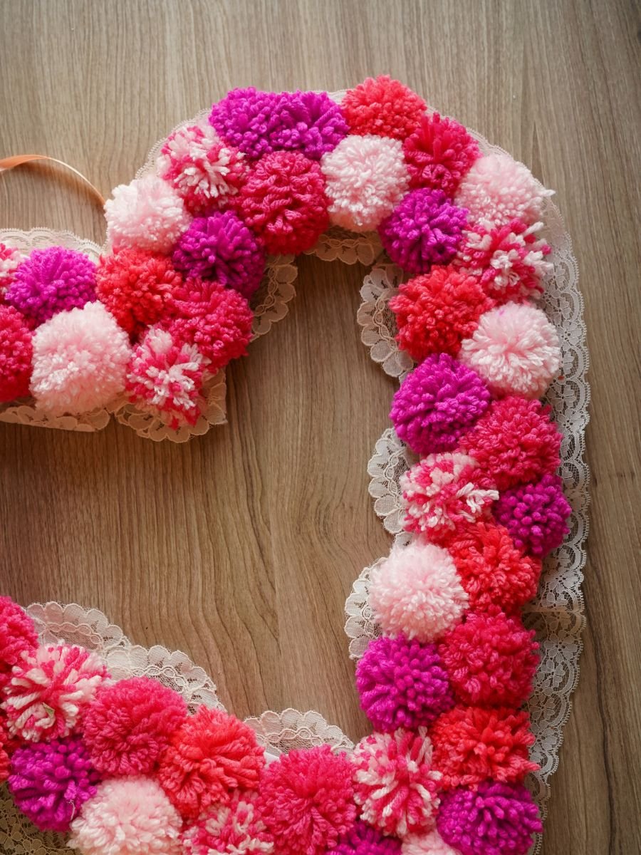 close up of finished heart pom pom wreath with lace trim