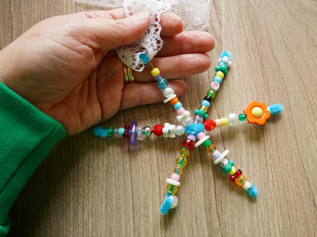 finished pipe cleaner snowflake in woman's hand