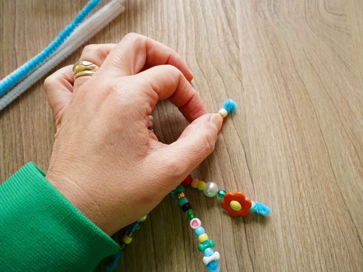 hand folding over the open end of pipe cleaner snowflake arm