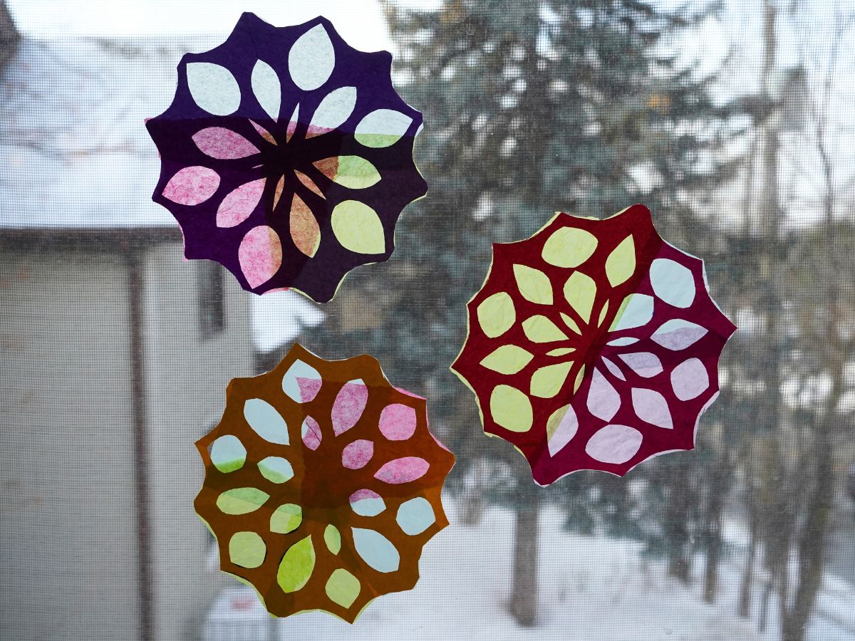 paper snowflake sun catchers hanging in window