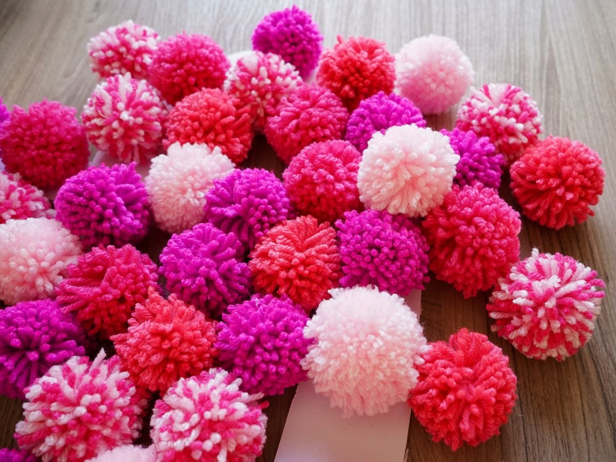 pile of pink and peach pom poms for valentine's day heart wreath