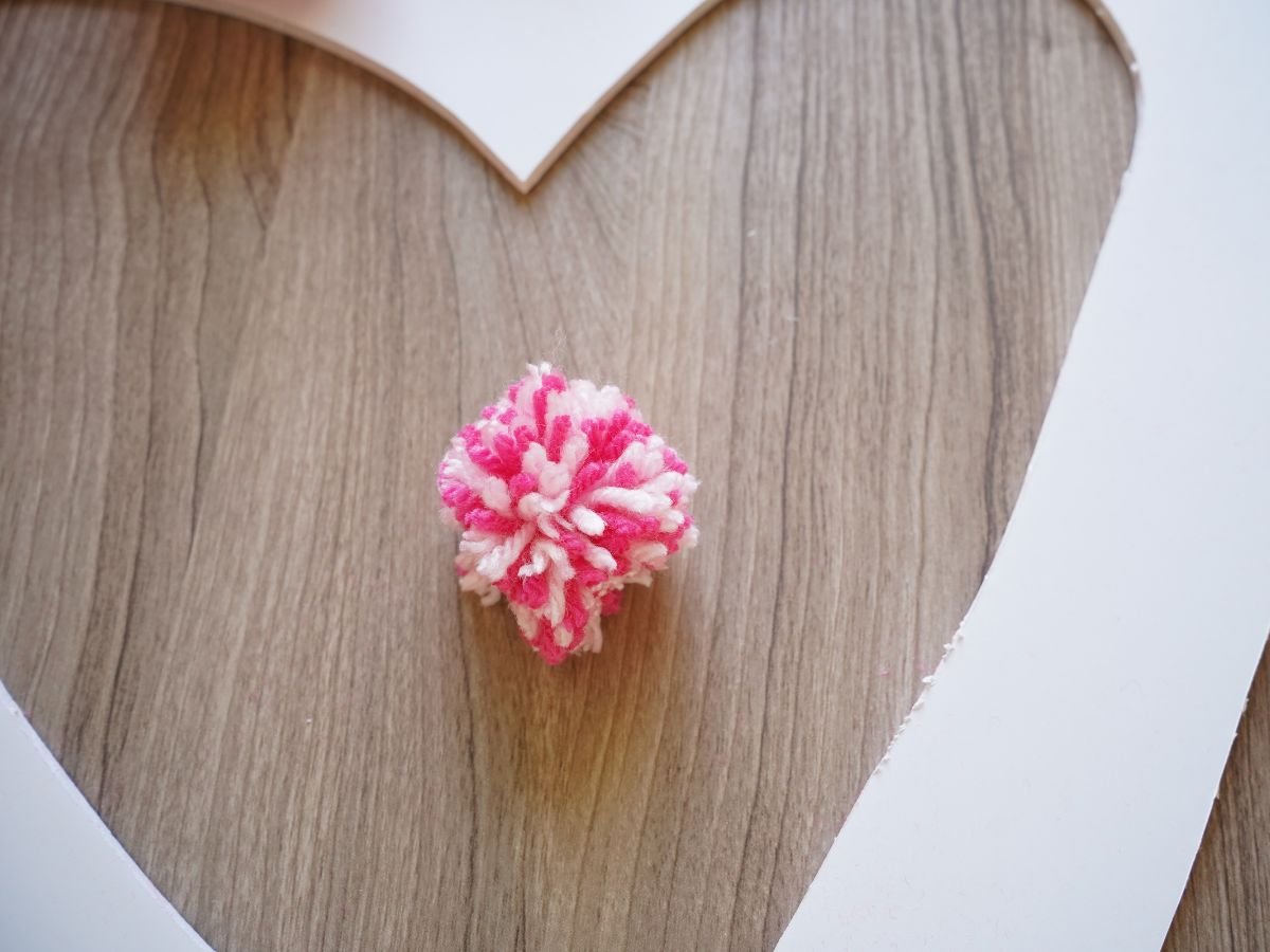 pink and white pom pom trimmed to have a point for point of heart wreath
