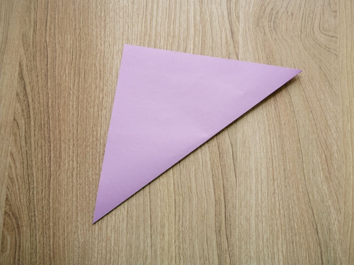 purple origami paper folded in half on diagonal