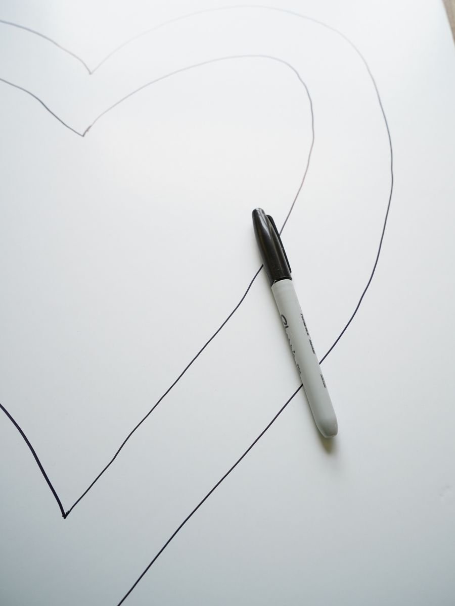 sheet of foam core with a heart drawn on and a black marker