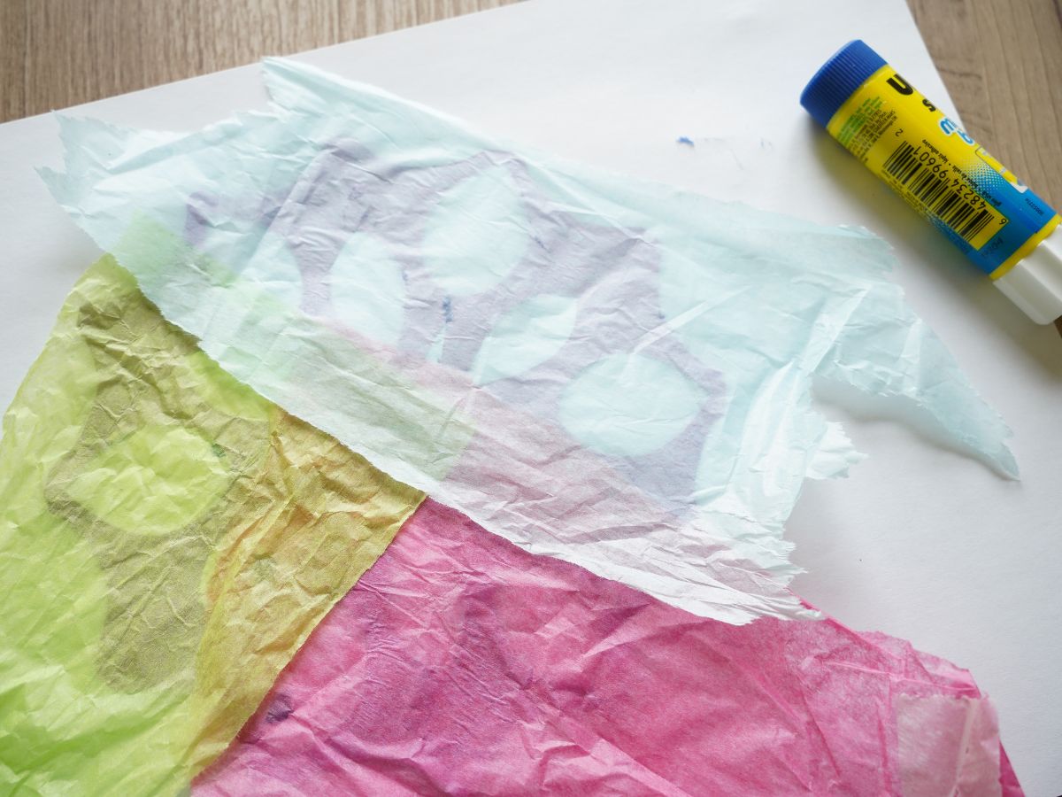 tissue paper glued to the back of a paper snowflake
