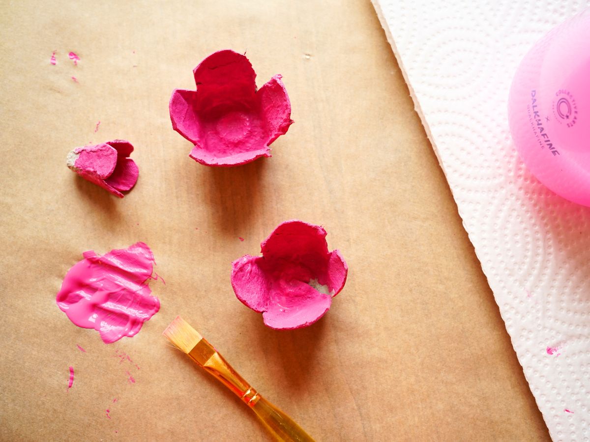 layers of egg carton rose being painted pink with paintbrush