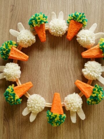 DIY Easter wreath with egg carton carrots and pom pom bunnies featured