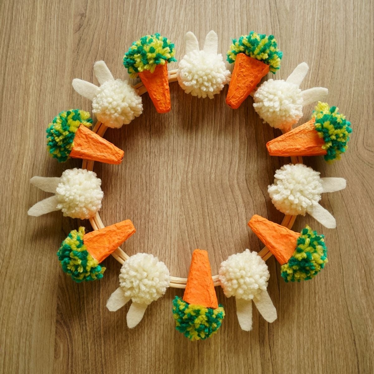 DIY Easter wreath with egg carton carrots and pom pom bunnies featured