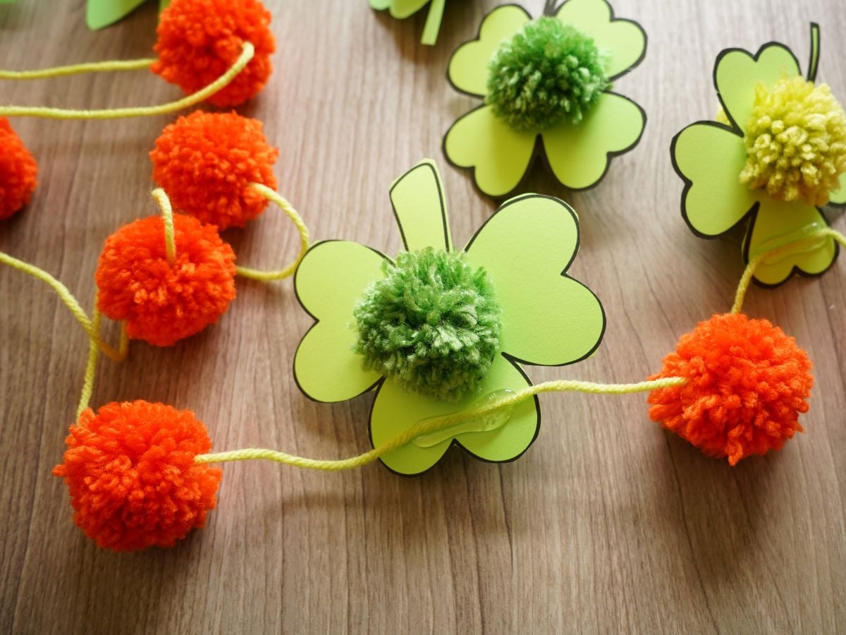 orange pom poms and pom pom shamrocks hot glued to garland