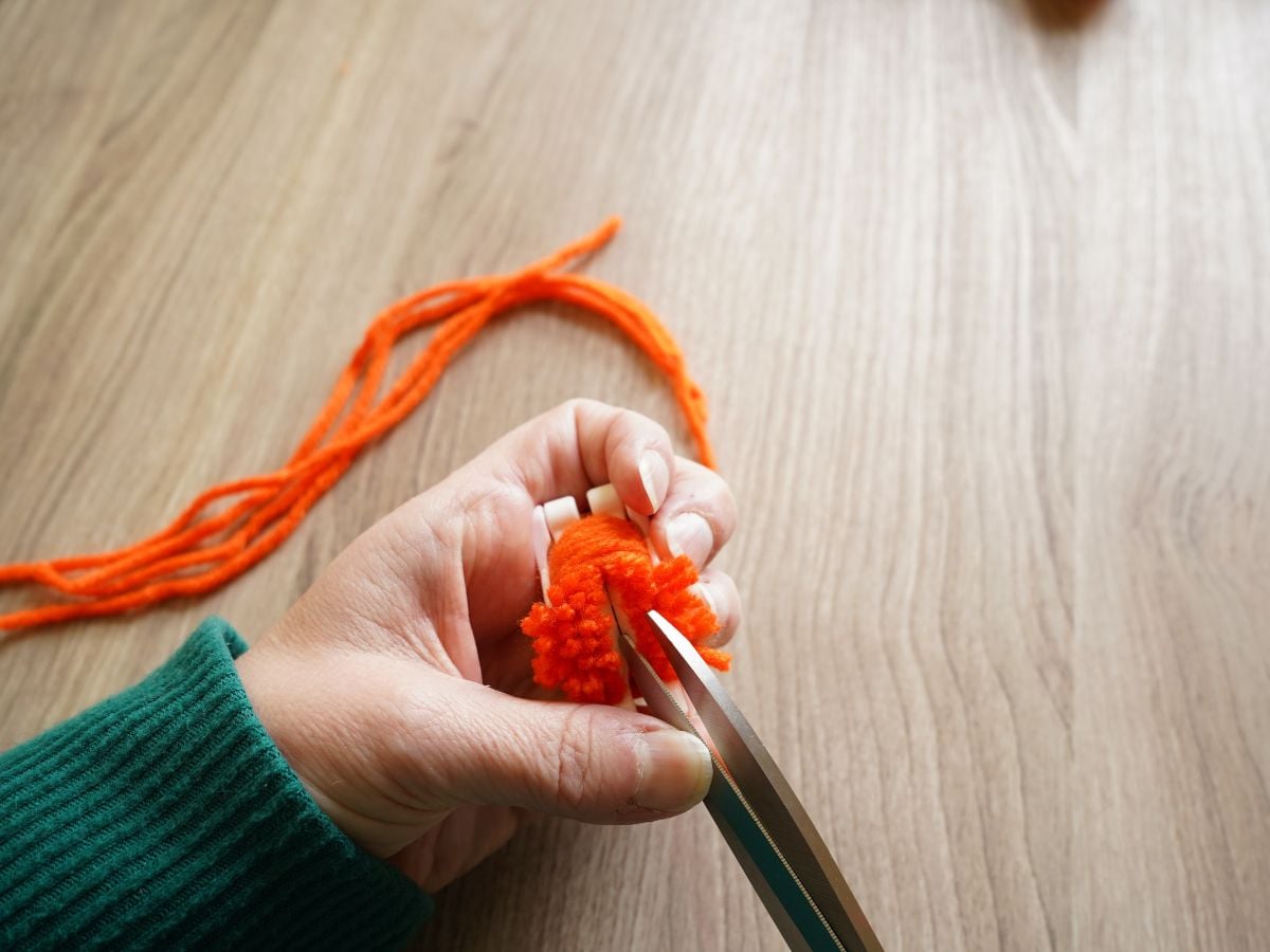 scissors cutting down channel in pom pom maker