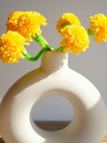 white vase filled with bouquet of bright yellow pom pom dandelions (1)