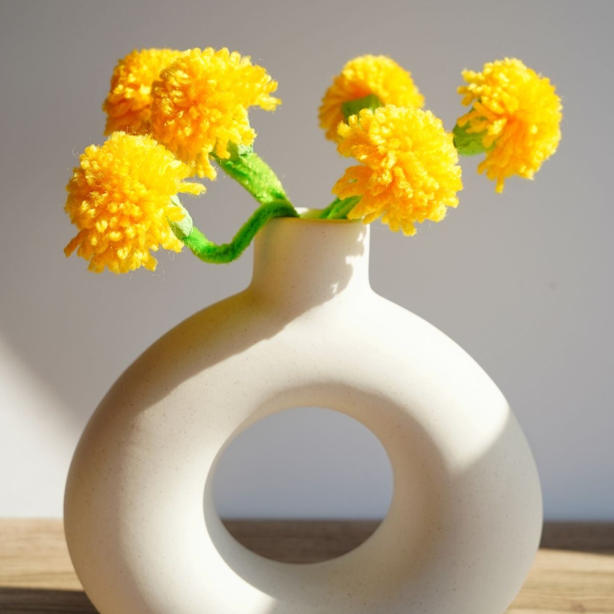 white vase filled with bouquet of bright yellow pom pom dandelions (1)