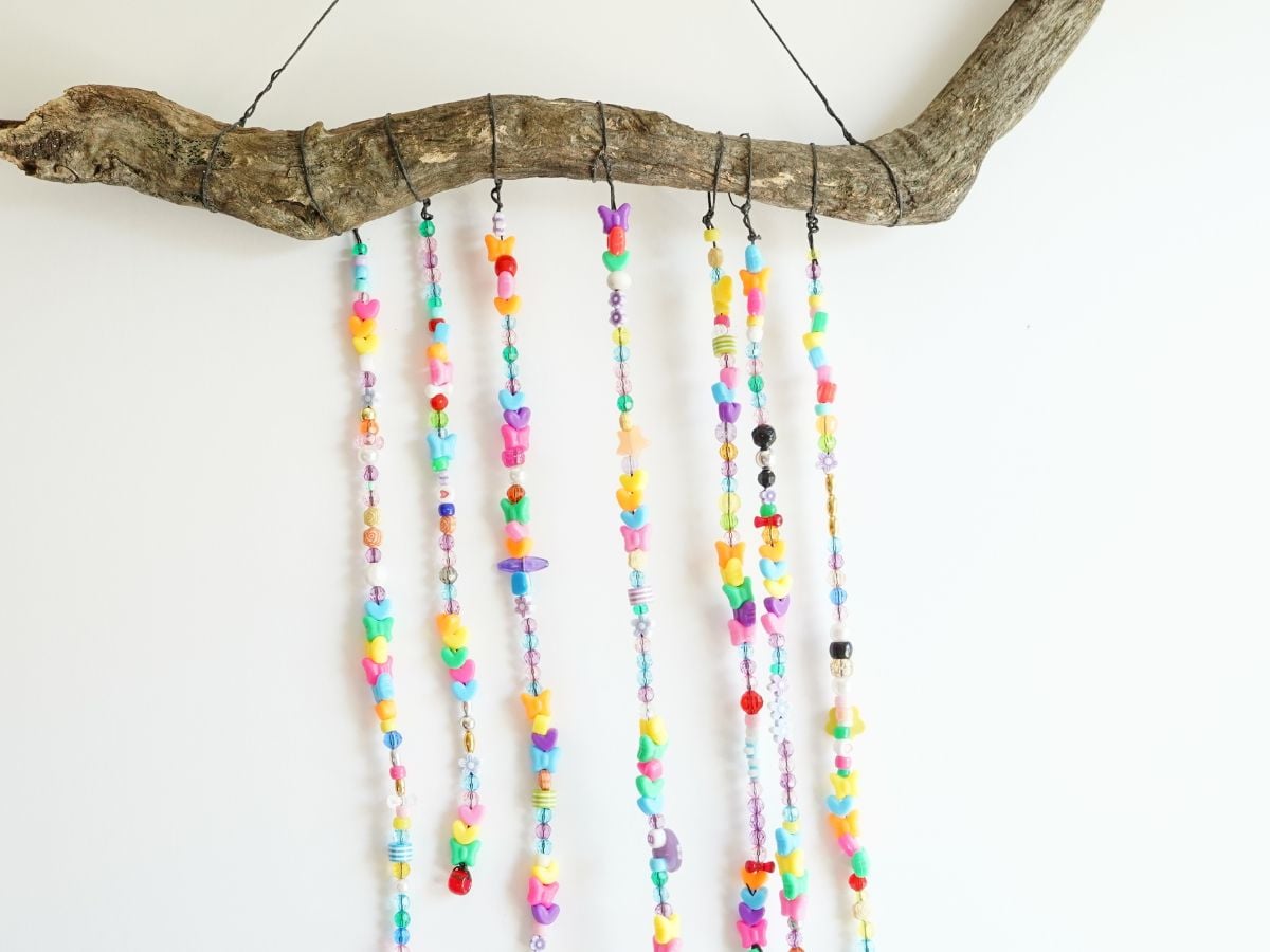 Copy of close up of colorfully beaded wind chime hanging with white background