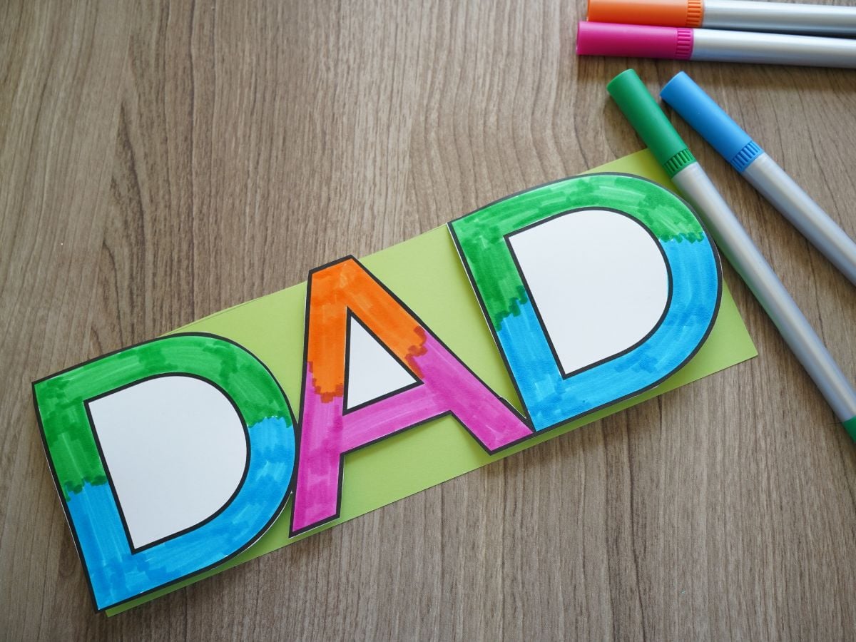 colored markers beside printable DAD coloring page frame colored in