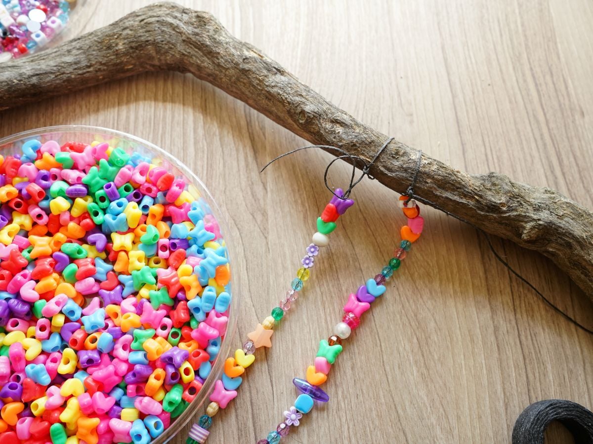 strand of beaded waxed linen string looped and tied onto a branch