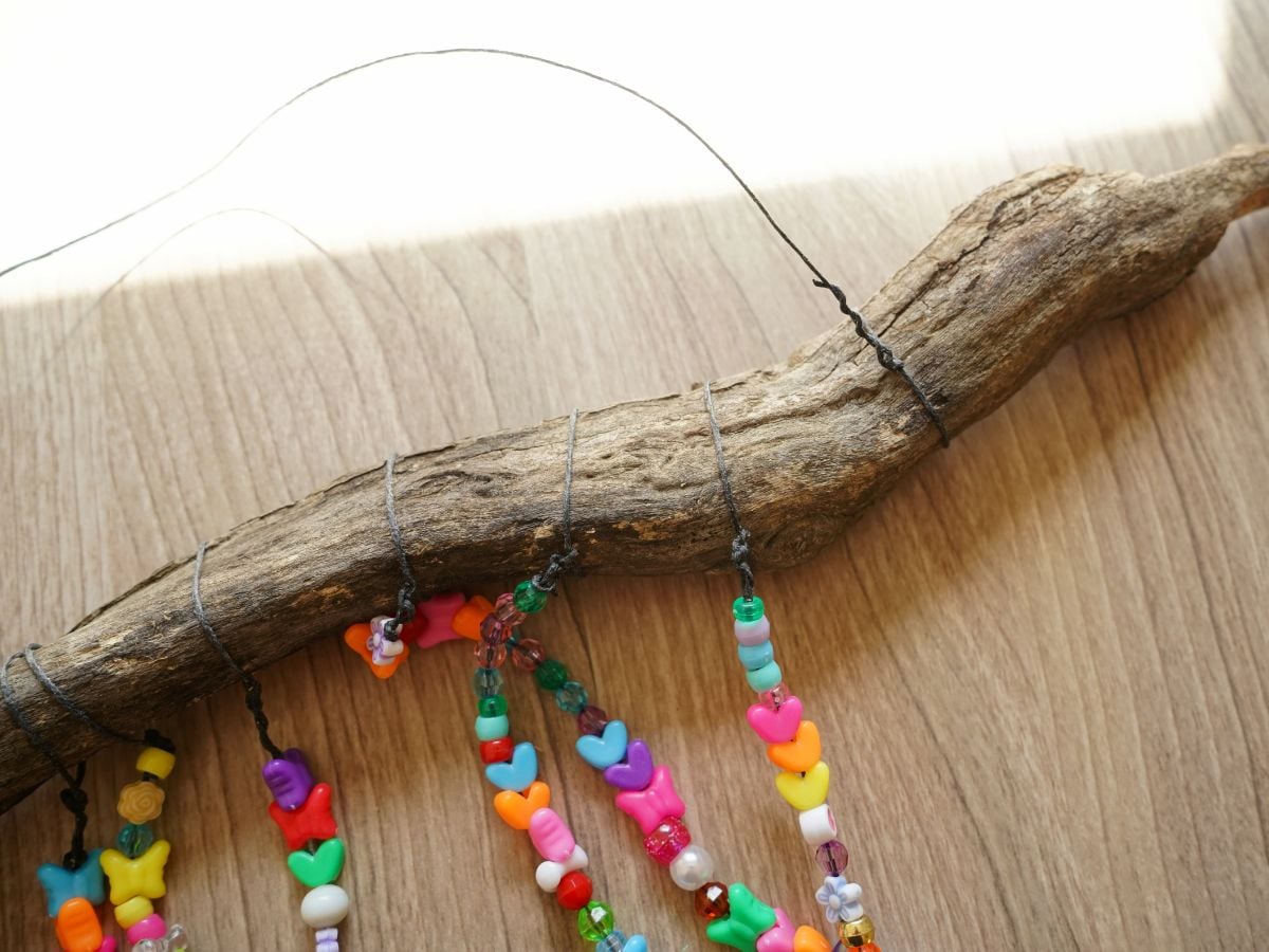 string of waxed linen looped around and tied to make hanger for beaded wind chime