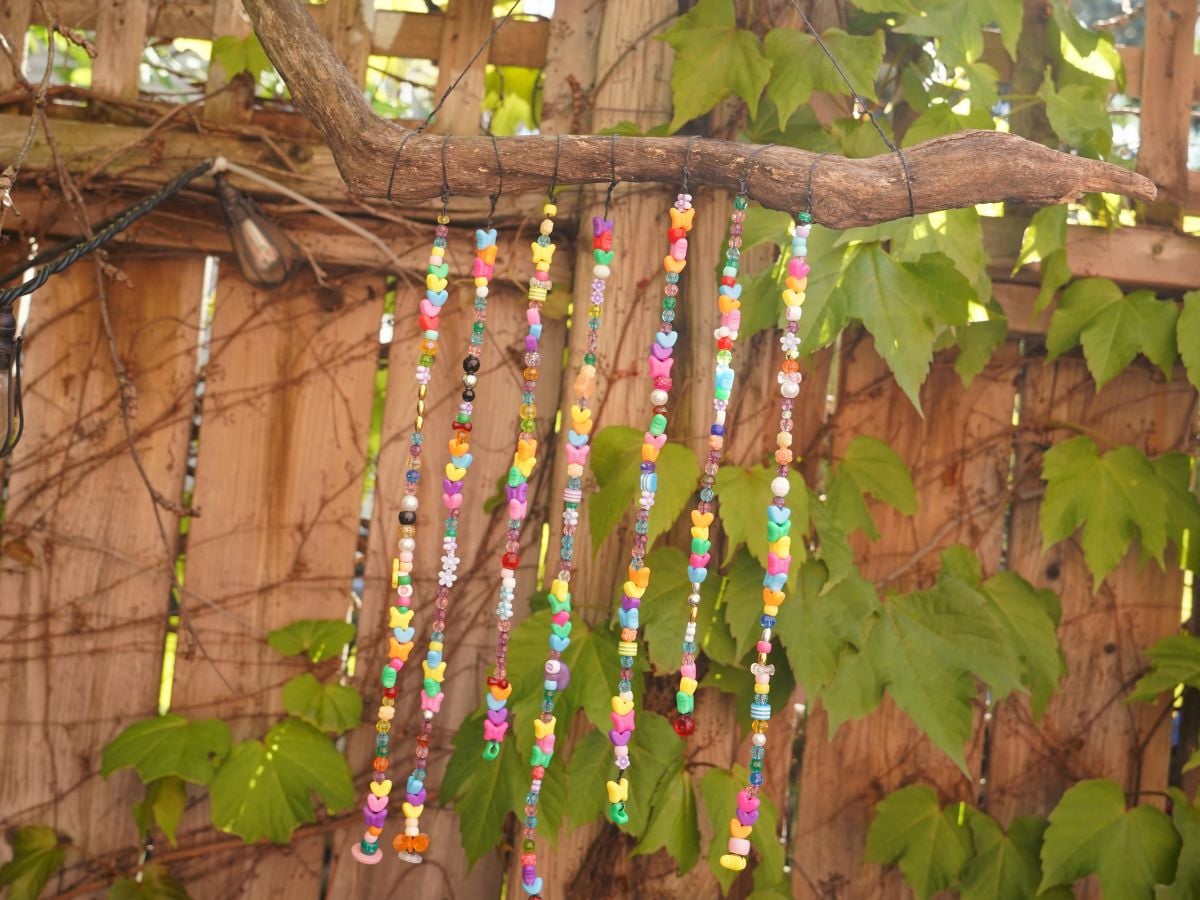 whimsical wind chime hanging in garden with colorful beads