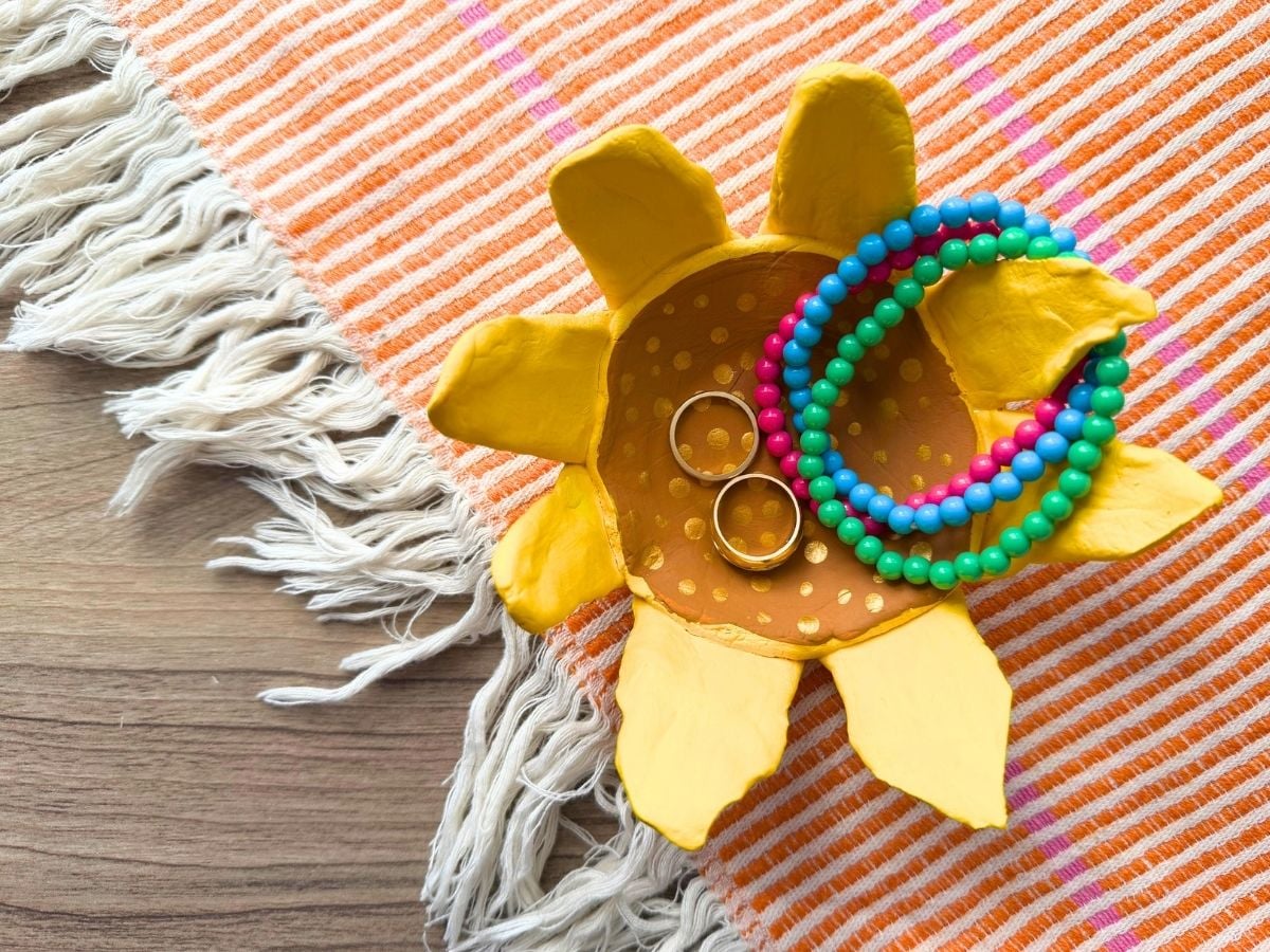 my sunflower bowl with my rings and bracelets inside of it on a table